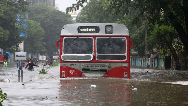 A passenger bus moves through a water-logged road during rains in Mumbai