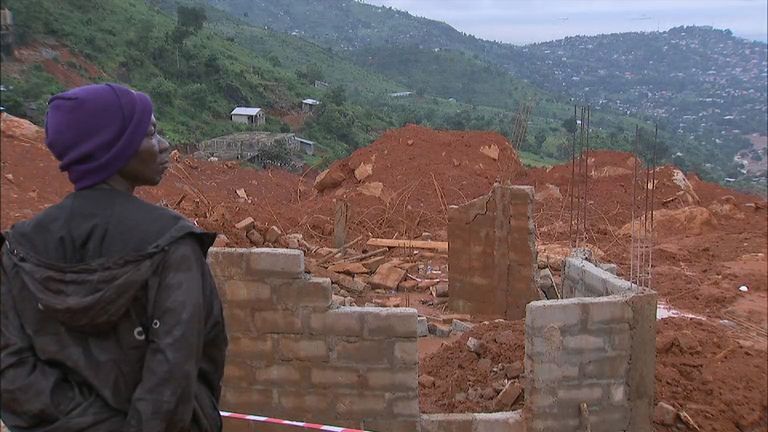 A resident looks down on the area where thousands of homes have been flattened and buried