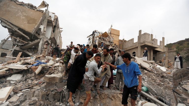 People search under the rubble of a house destroyed by a Saudi-led air strike in Sanaa
