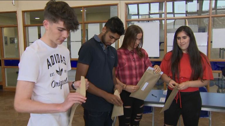 Students open envelopes containing their GCSE results