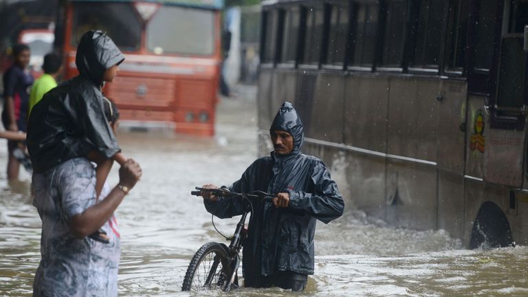 Wading through a flooded street during heavy rain in Mumbai