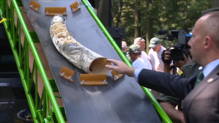 Officials dispose of carved ivory in a crushing machine in New York's Central Park