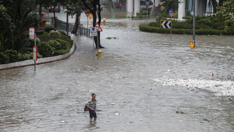 A man walks through a flooded street as Typhoon Hato hits Hong Kong