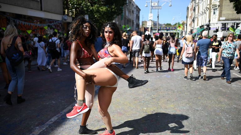 Revellers walk through Notting Hill Carnival