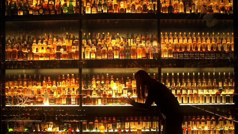 A member of staff looking at the Diageo Claive Scotch Whisky collection