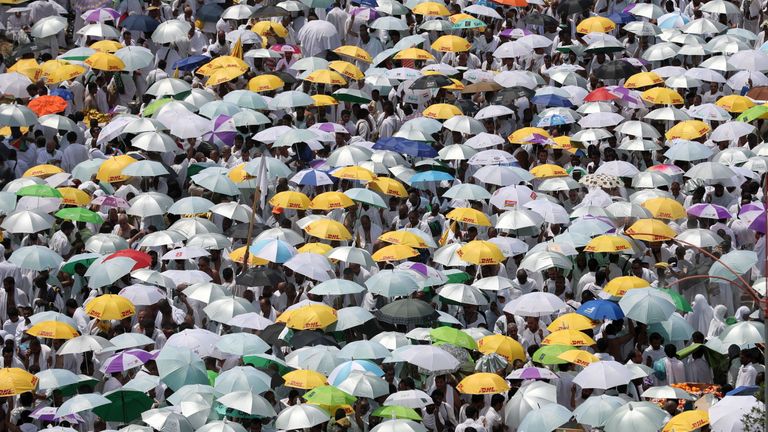 Muslim worshipers, carrying umbrellas to protect them from the scorching sun, gather for the noon prayer at Namirah mosque near Mount Arafat