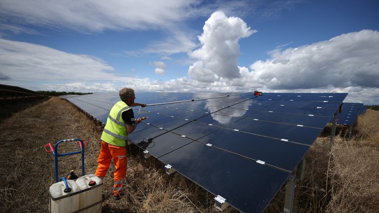 A workman cleans panels at Landmead solar farm on July 29, 2015 near Abingdon, England