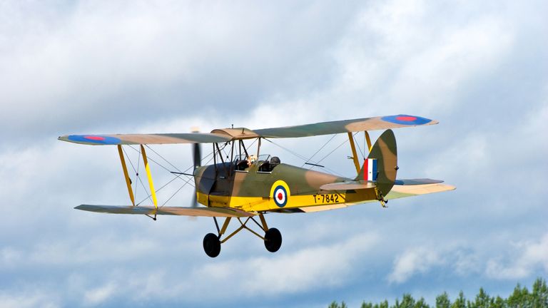 Headcorn Kent England UK - August 13th 2011: An RAF DH82A Tiger Moth bi-plane restored in its original colors in the air at an air display in Kent UK