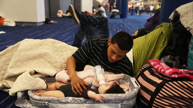 Mark Ocosta feeds his baby son Aubrey at a shelter in Houston