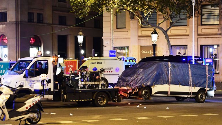 The van who ploughed into the crowd, killing at least 13 people and injuring around 100 others is towed away from the Rambla in Barcelona