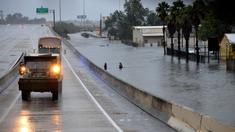 Rescue vehicles drive past the flooded Interstate 610 in Houston