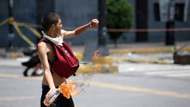 A demonstrator throws a Molotov cocktail 