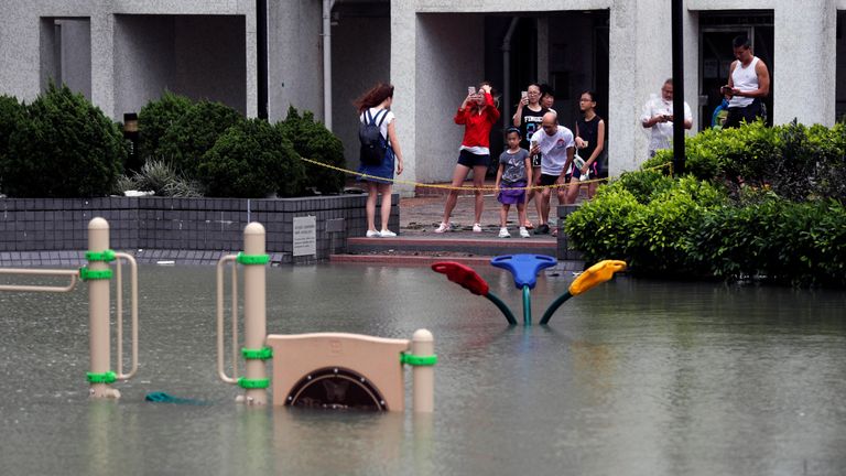 People look at a flooded playground after Typhoon Hato hits Hong Kong,