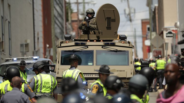 A Virginia State Police officer in riot gear keeps watch from the top of an armored vehicle after car plowed through a crowd of counter-demonstrators