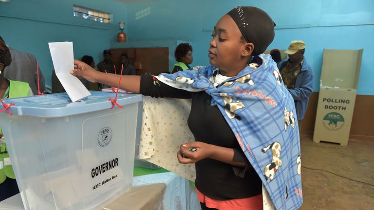 A woman votes in the too-close-to-call battle between incumbent Uhuru Kenyatta and his rival Raila Odinga.