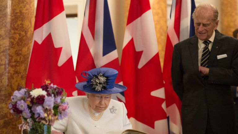 Queen Elizabeth II and Prince Philip, Duke of Cambridge sign the visitors book during their visit to Canada House on July 19, 2017 in London, England