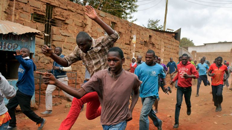 Protesters run away after riot police fired live rounds in the Kibera slum in Nairobi