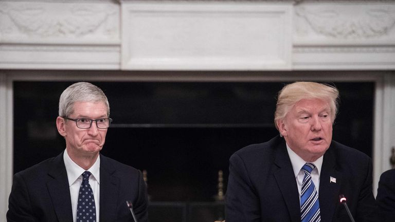 Apple CEO Tim Cook listens to US President Donald Trump during a tech summit  at the White House in June