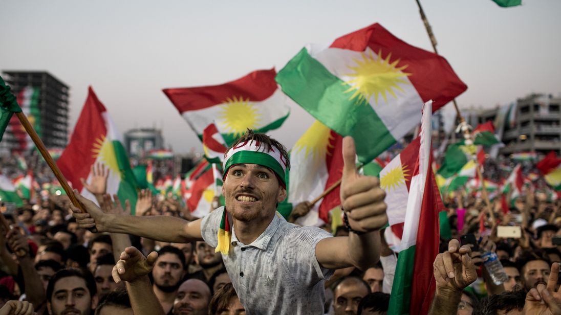 Supporters wave flags and chant slogans inside the Erbil Stadium while waiting to hear Kurdish President Masoud Barzani