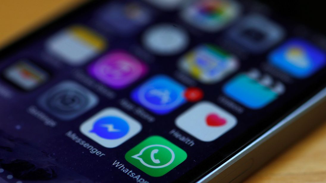 WhatsApp and Facebook messenger icons are seen on an iPhone