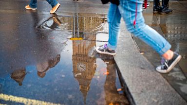 Big Ben heijastuu lätäkkönä suihkun jälkeen Lontoon keskustassa 
