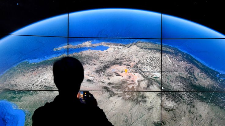 A man looks at a Google Earth map on a screen as Google Earth unveils the revamped version of the application April 18, 2017 at a event at New York's Whitney Museum of Art