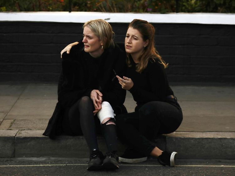 An injured woman reacts outside Parsons Green tube station