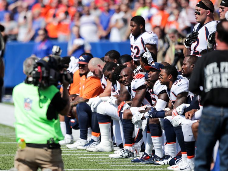 Denver Broncos players kneel during the American National Anthem before an NFL game against the Buffalo Bills