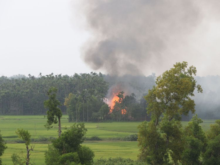 Thick black smoke rises from what is believed to be a burning village in western Myanmar