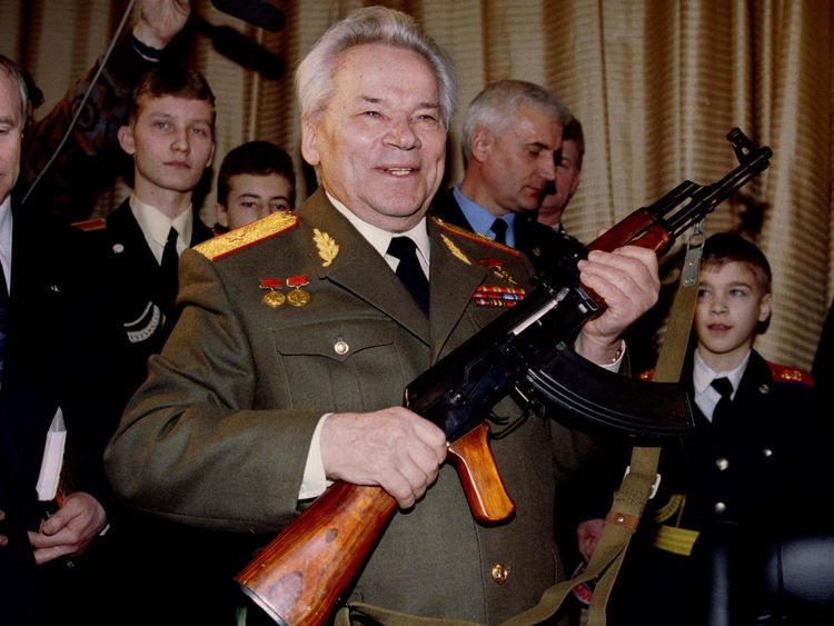 Mikhail Kalashnikov, pictured in 1997, holds aloft an AK-47