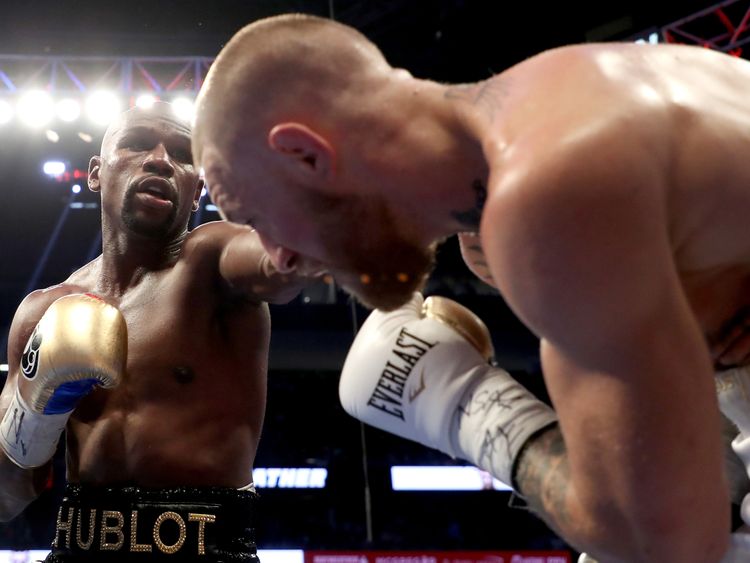 LAS VEGAS, NV - AUGUST 26:  (L-R) Floyd Mayweather Jr. throws a punch at Conor McGregor during their super welterweight boxing match on August 26, 2017 at 