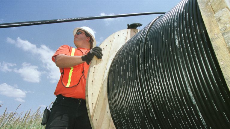 A man installing fibre-optic cable. File photo.