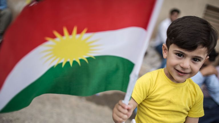 An Iraqi Kurdish boy holds a Kurdish flag at a school in Arbil which is being used as a polling station as voters cast their ballots in the Kurdish independence referendum on September 25, 2017. Iraqi Kurds voted in an independence referendum, defying warnings from Baghdad and their neighbours in a historic step towards a national dream