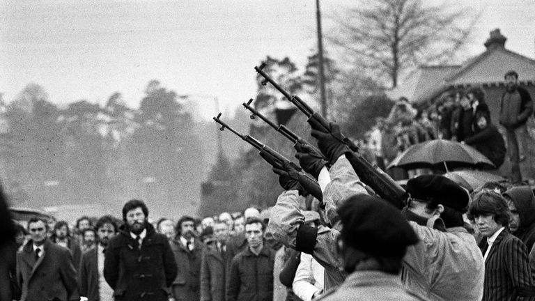 May 1981: Three masked IRA men fire volleys of rifle shots over the coffin of hunger-striker Bobby Sands. Belfast. Gerry Adams can be seen in background