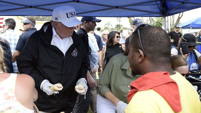 US President Donald Trump helps serve food to people affected by Hurricane Irma, in Naples, Florida, on September 14, 2017. / AFP PHOTO / Brendan Smialowski (Photo credit should read BRENDAN SMIALOWSKI/AFP/Getty Images)