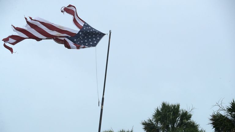 A US flag is tattered by strong winds from Hurricane Irma in Florida