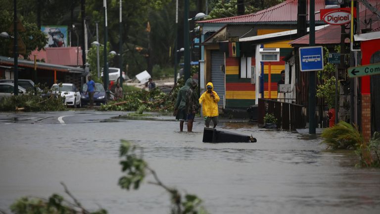 People walk in a flooded street after the passage of Hurricane Maria in Pointe-a-Pitre, Guadeloupe island