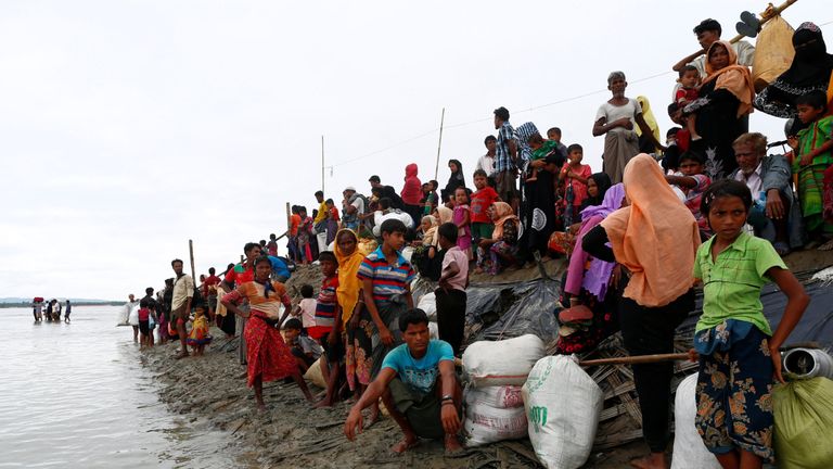 Rohingya refugees wait at a jetty after crossing the Bangladesh-Myanmar border by boat through the Bay of Bengal in Shah Porir Dwip