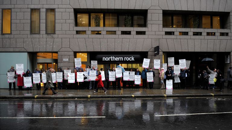 Representatives of smaller shareholders in Northern Rock hold placards outside a branch of the bank, in London January 12, 2009