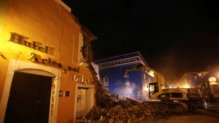 A machine works on a destroyed hotel 
