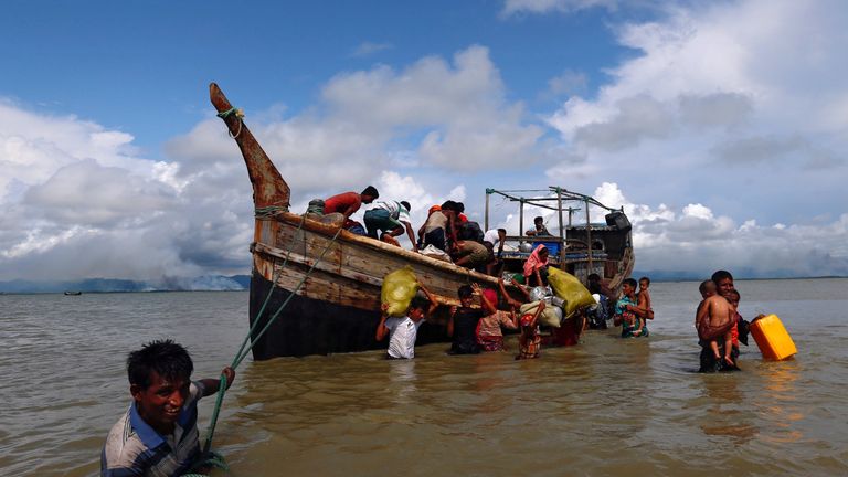Rohingya refugees get off a boat after crossing the Bangladesh-Myanmar border through the Bay of Bengal