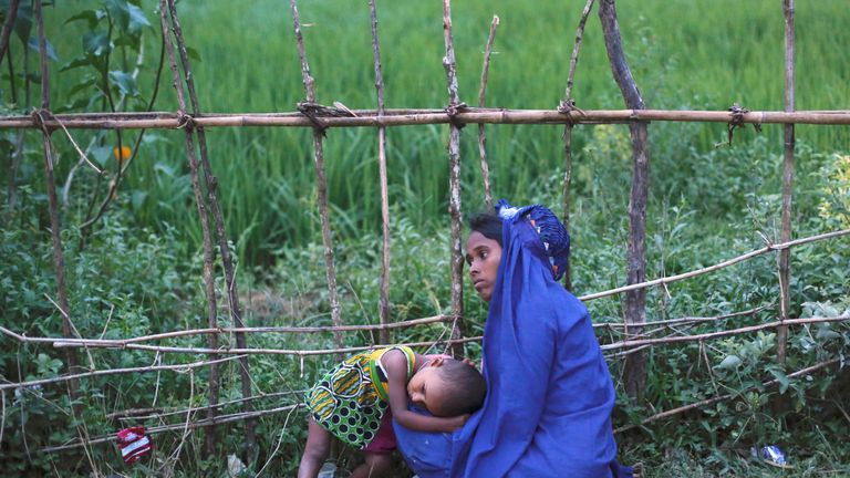 An exhausted Rohingya refugee rests with her daughter after jostling for aid outside a camp in Cox&#39;s Bazar, Bangladesh