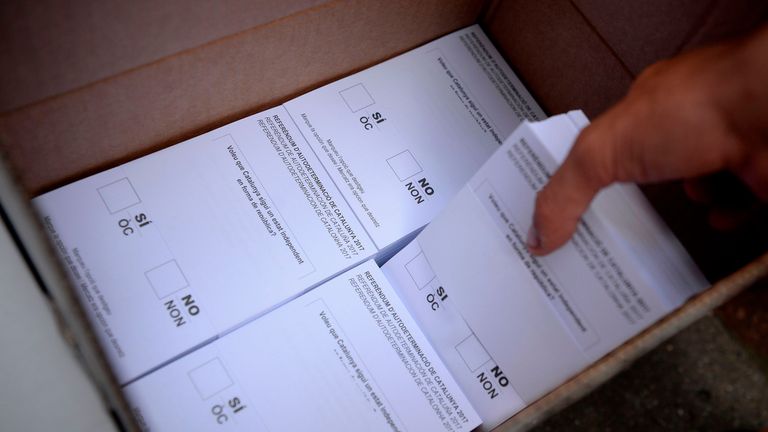 A Pro-referendum demonstrator grabs a pack of ballots before their distribution to passer-by during a demonstration