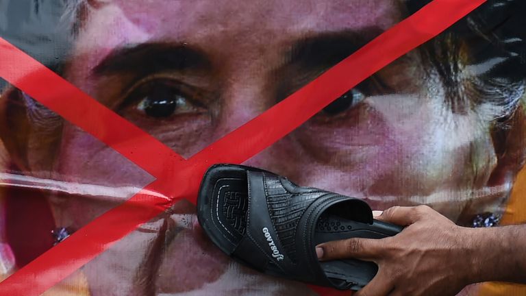 A Rohingya refugee living in Malaysia uses a slipper to hit a picture of Aung San Suu Kyi 