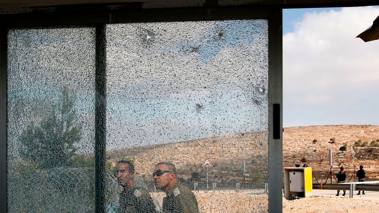 TOPSHOT - Members of the Israeli security forces walk past the shattered glass of the security post at the entrance to the West Bank settlement of Har Adar after a Palestinian opened fire on security personnel in a fatal attack before being shot dead on September 26, 2017. / AFP PHOTO / Menahem KAHANA (Photo credit should read MENAHEM KAHANA/AFP/Getty Images)