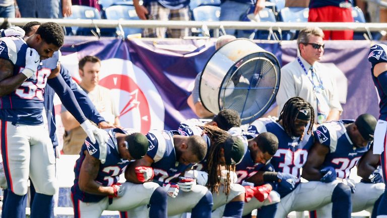 Members of the New England Patriots kneel on the sidelines as the National Anthem is played before a game against the Houston Texans at Gillette Stadium