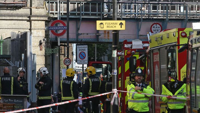 Members of the emergency services work outside Parsons Green station after the attack