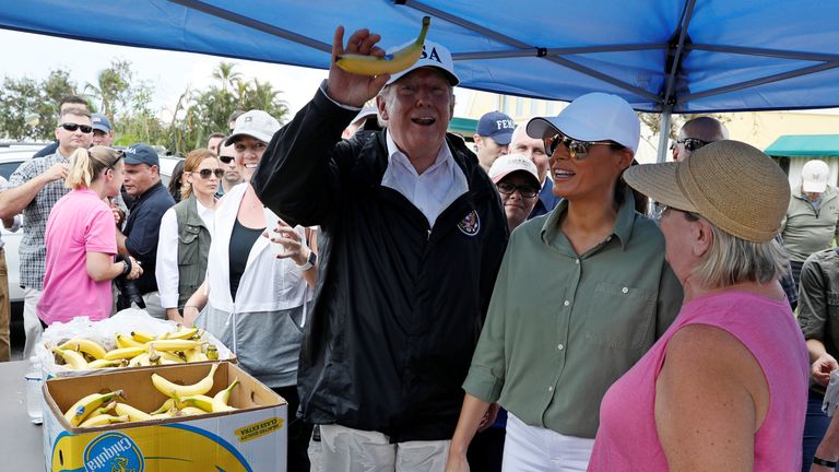 Trump holds up a banana while distributing food alongside his wife Melania to people impacted by Irma in Naples, Florida