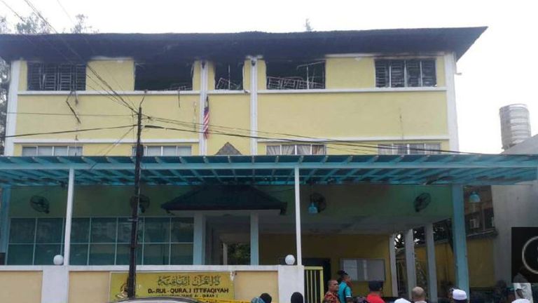 People gather outside the religious school Darul Quran Ittifaqiyah after a fire broke out in Kuala Lumpur