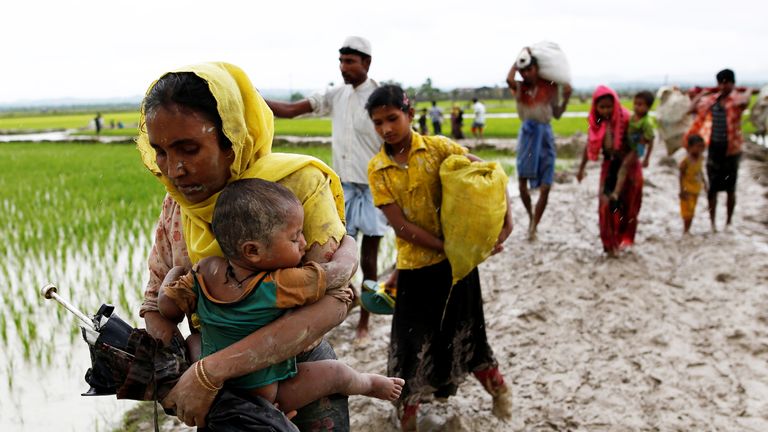 A Rohingya woman and her child travel to Bangladesh from Myanmar